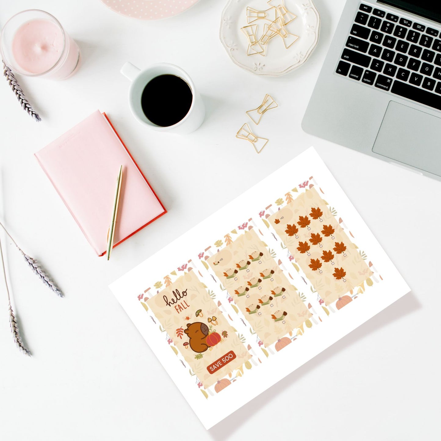 Desk setup with stationery items including a laptop, notebook, and coffee cup.