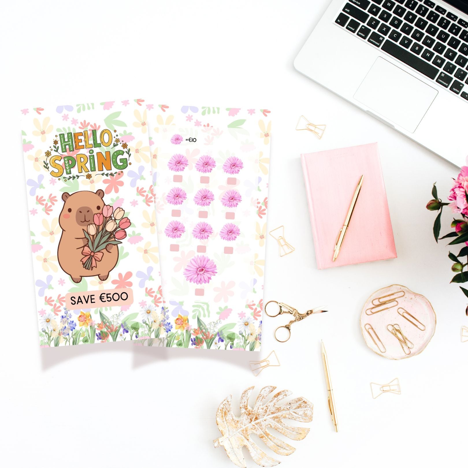 Spring-themed stationery items on a desk with a laptop and flowers.