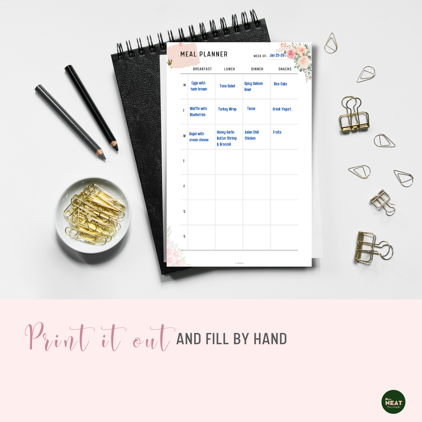 Floral Weekly Meal Planner Printable printed out on paper and put on the black book with stationery surround